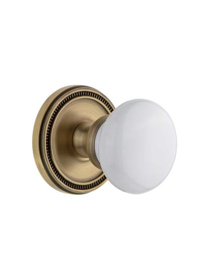 Grandeur Soleil Rosette Door Set with Hyde Park Porcelain Knobs in Antique Brass.